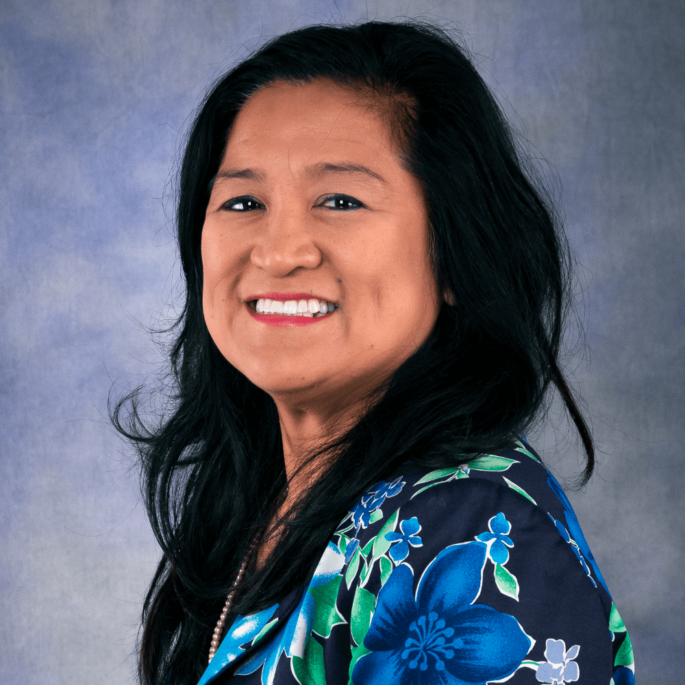 Headshot of Arlene Satele in a blue and green blouse
