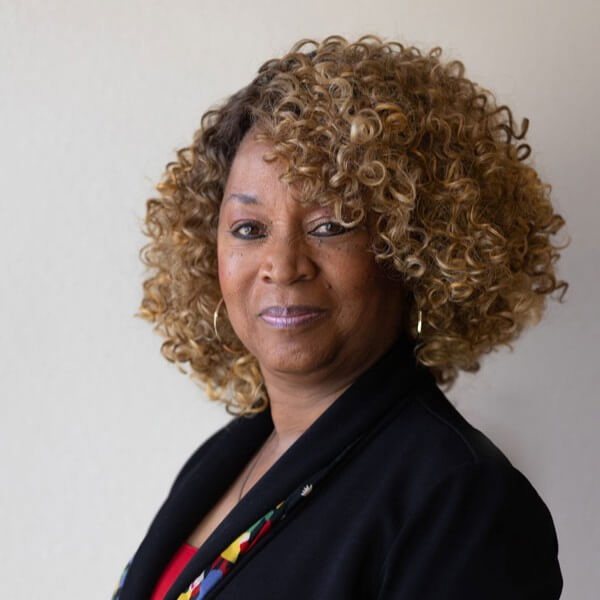 Professional headshot of Dr. Kim Armstrong in a black suit jacket