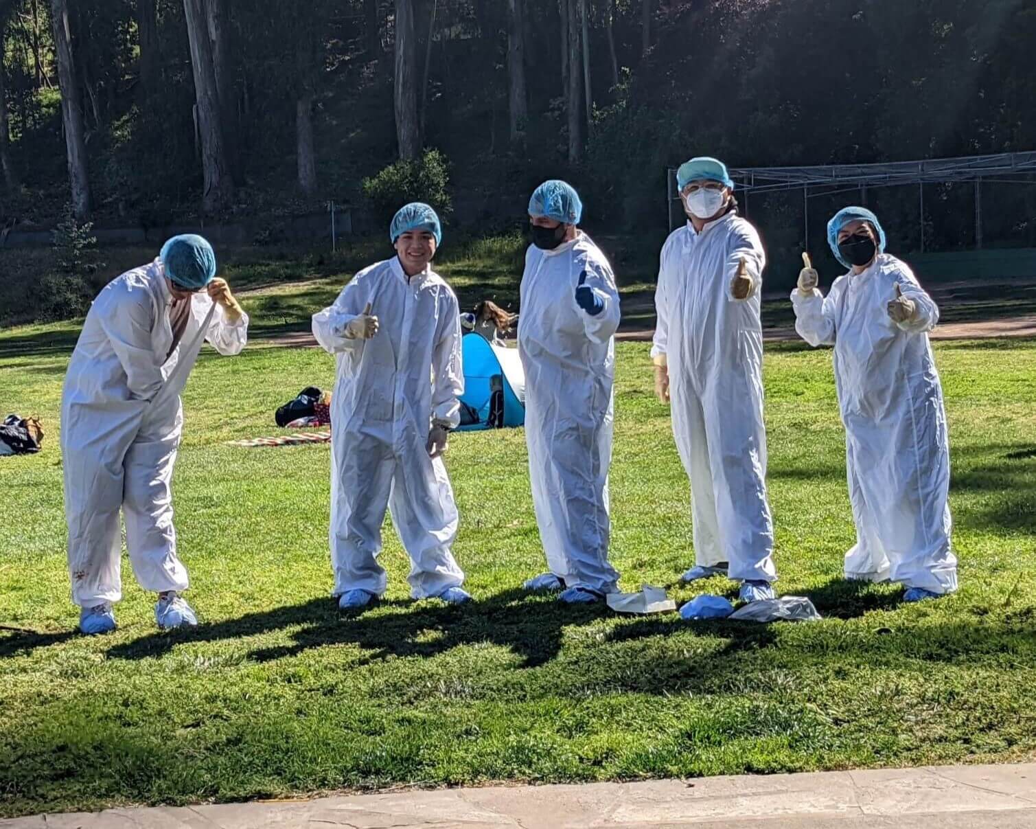 5 students participate in a contest on speed-dressing in lab gear at an event