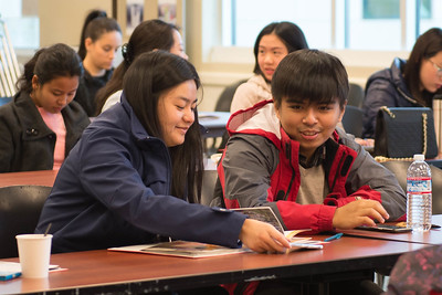 two international students collaborate at a desk