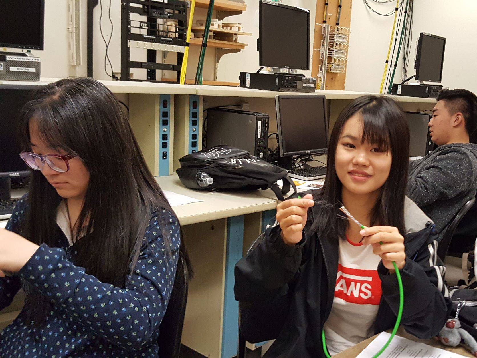 A student examines a wire cable during lab