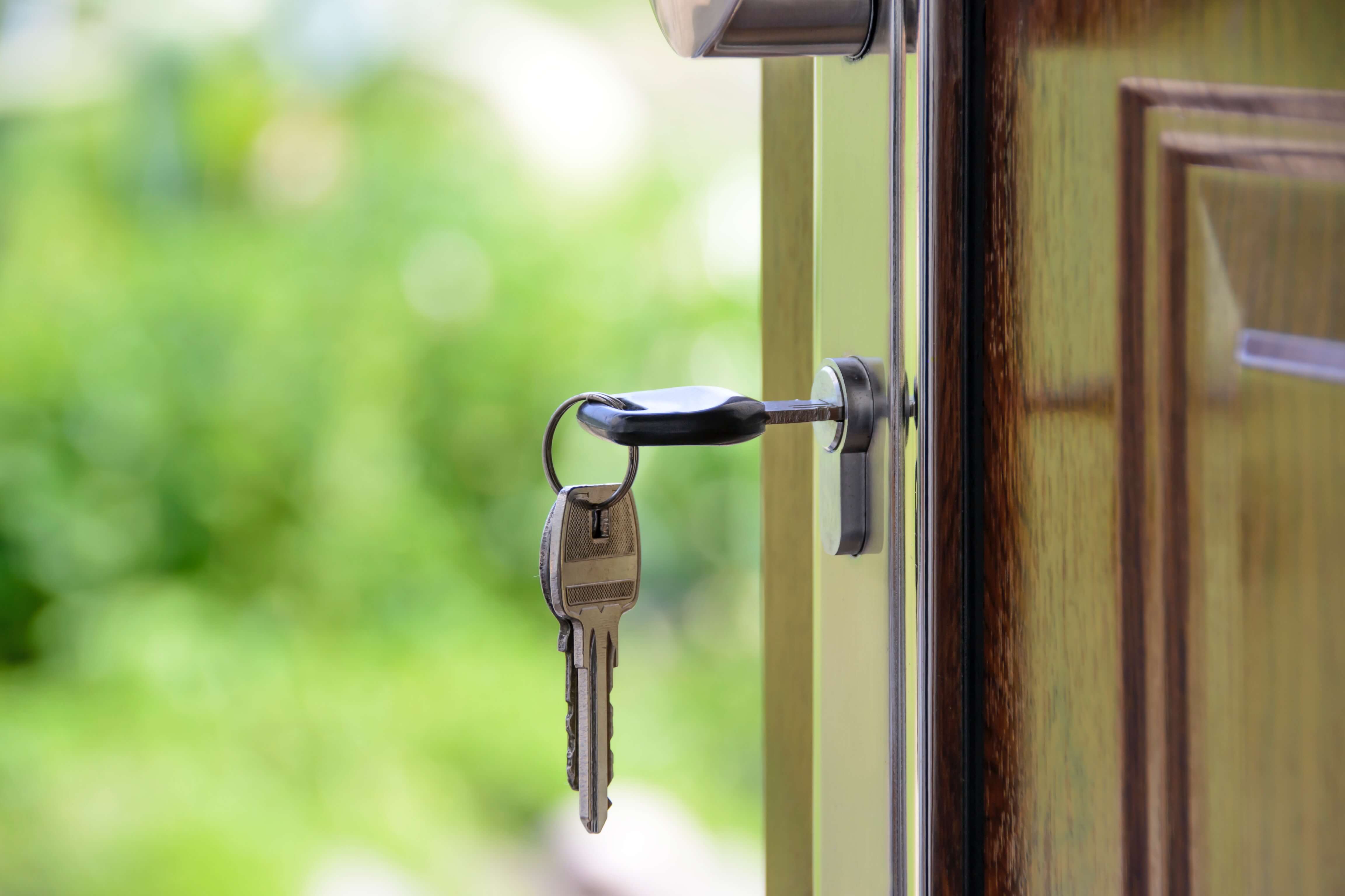 a key hangs out of a lock on a door